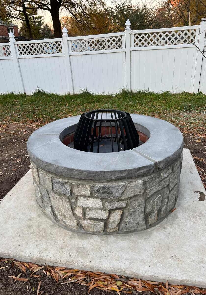 A fire pit with a grill sitting on top of it.